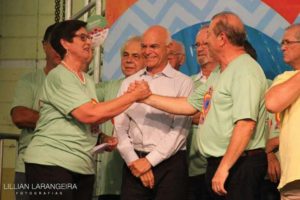 A presidente da Feira da Bondade, Mariza Müller, cumprimenta o presidente da APAE, Gentil Pacioni Jr., sob os olhares do prefeito em exercício, Antonio Carlos Pinheiro, do fundador e ex-presidente da APAE, Celino Roncato e João Scalfi.